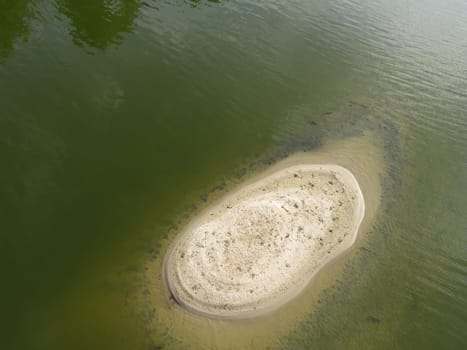 small island in a river surrounded by water and composed of sand