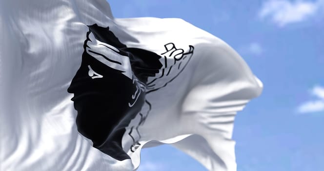 The flag of Corsica waving in the wind on a clear day. The Corsica is an island of the Mediterranean Sea and French administrative region