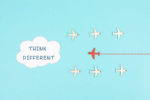 Group of airplanes flying, red plane thinks different and takes the opposite direction, against the stream symbolic, courage and winner concept