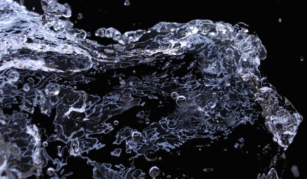 Isolated splashes of water on a black background. Abstract background. Ecological concept..