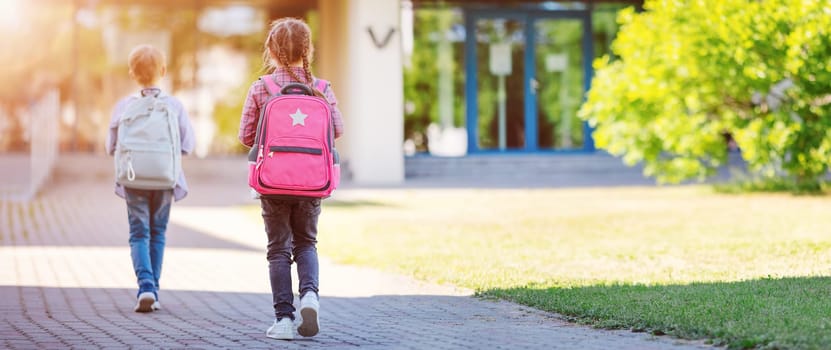 Girl and boy going to the school to study at it. Concept of back to school and friendship.