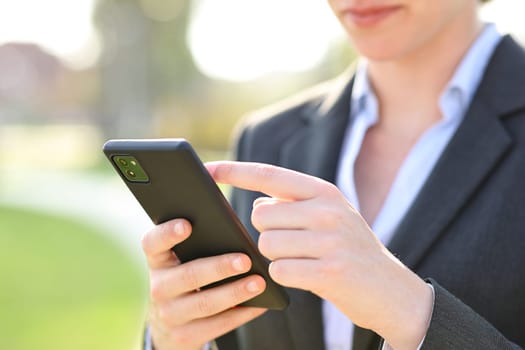 Close up portrait of an executive hand using smartphone in a park