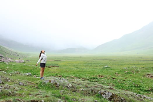 Full body portrait of a trekker breathing fresh air in the mountain a foggy day