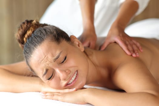 Woman complaining and physiotherapist doing massage to remove a contracture