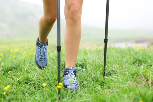 Close up of a hiker legs walking on the grass a foggy day in the mountain