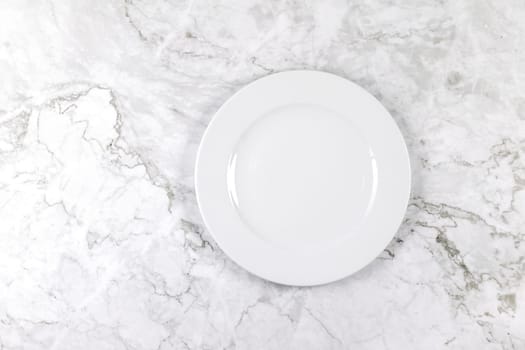 A dinner plate on a white and grey marble surface