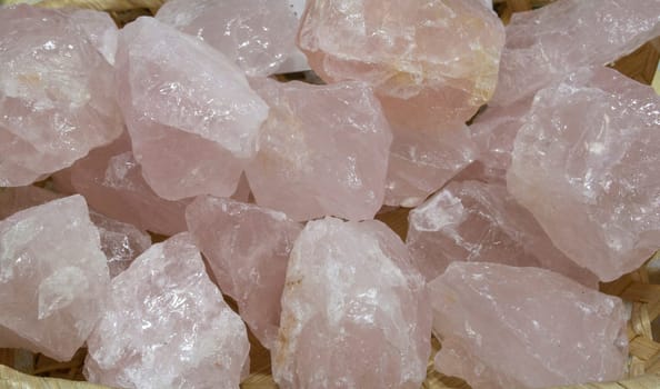 Rose quartz fragments, believed to have beneficial health properties. Displayed on basket at street market stall