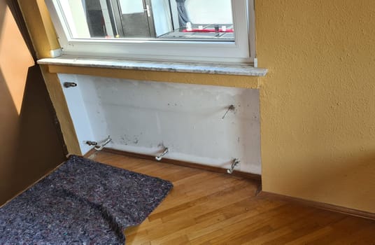 Dismantling a broken radiator in a private house. Radiator.