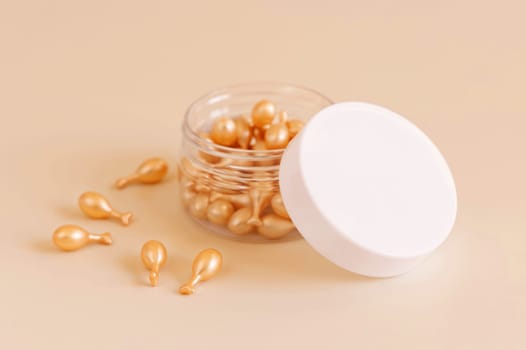 Beauty serum capsules in a jar on light yellow close up. Skincare cosmetics. Facial treatment with perfect dosage of serum to be used. Pastel minimal composition..