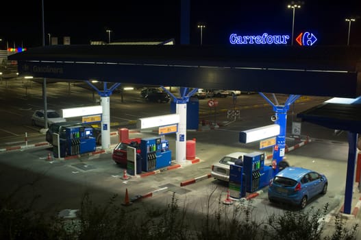 Badajoz, Spain - Jan 21st, 2019: Costumers refuelling at night. Carrefour Petrol Station, Badajoz, Spain