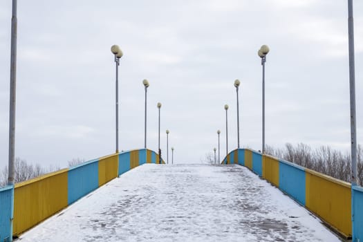 Pedestrian bridge in Chernihiv across the Desna river in the snow on a winter snowy day