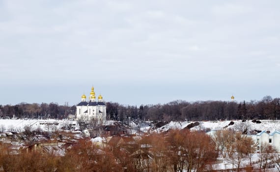 Orthodox Church of St. Catherine in the Ukrainian city of Chernihiv and a view of the city in winter with snow. Old beautiful temple in the city
