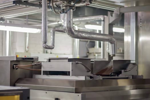 Line for the production of chocolate in an industrial factory. Automatic process in the production line of sweets. Images from the chocolate factory during production. Conveyor belt with sweets