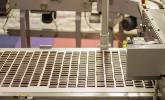 Line for the production of chocolate in an industrial factory. Automatic process in sweets production line during production. Conveyor belt with sweets. Ukraine, Kiev - February 09, 2022