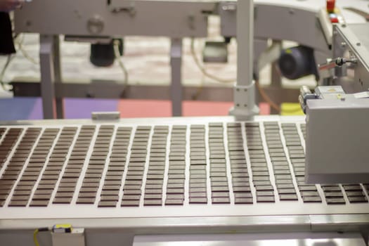 Line for the production of chocolate in an industrial factory. Automatic process in sweets production line during production. Conveyor belt with sweets. Ukraine, Kiev - February 09, 2022
