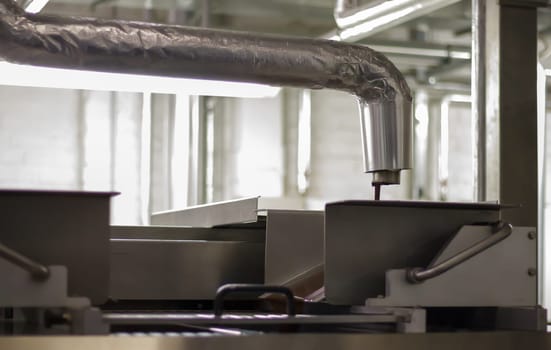 Line for the production of chocolate in an industrial factory. Automatic process in the production line of sweets. Images from the chocolate factory during production. Conveyor belt with sweets