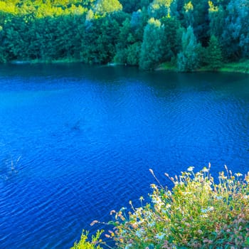 Beautiful quarry lake dredging pond lake with blue turquoise water blue sky and landscape nature forest panorama view in Eggestedt Schwanewede Osterholz Lower Saxony Germany.