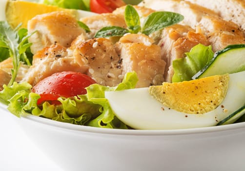 Fresh green salad with chicken breast and boiled egg close up