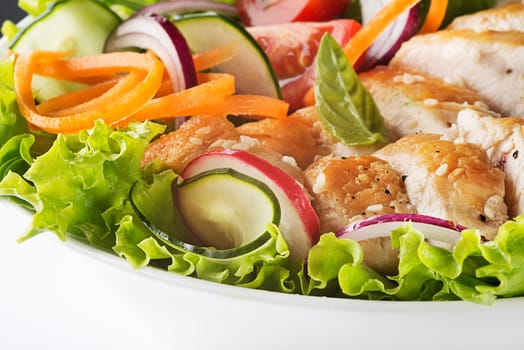 Healthy green salad with chicken breast and fresh vegetables close up