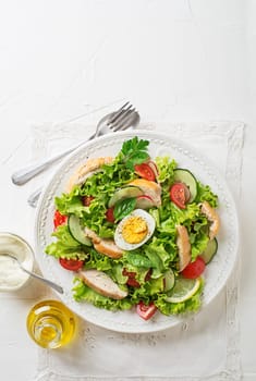 Fresh green salad with chicken breast vegetable and boiled egg on white background