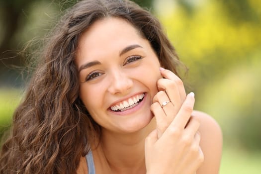 Front view portrait of a happy bride with perfect smile showing engagement ring