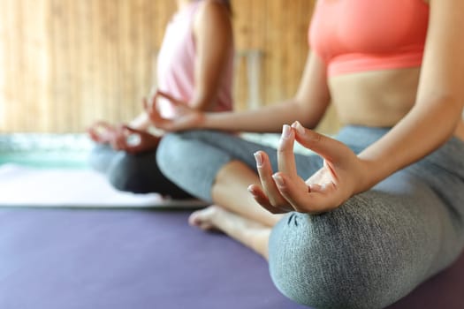 Close up of two women hands doing yoga in spa
