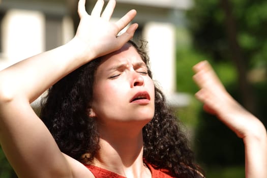 Overwhelmed woman suffering heat stroke a sunny day in a park