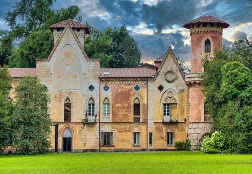 ITALY, MIRADOLO - CIRCA AUGUST 2020: gothic design castle located in an Italian garden, full of mystery, with sunset light.