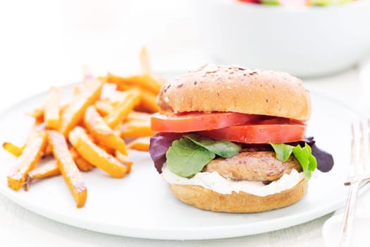 Grilled portobello mushroom burger on whole wheat bun with sweet potato fries.