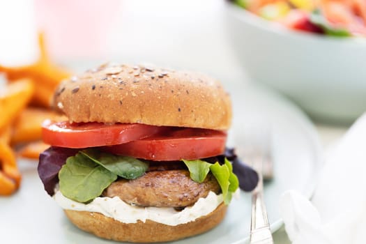Grilled portobello mushroom burger on whole wheat bun with sweet potato fries.