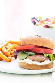 Grilled portobello mushroom burger on whole wheat bun with sweet potato fries.