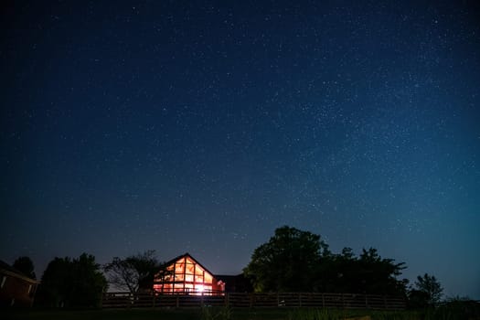View of night sky and the Milky Way with a house in rural Kentucky in the foreground