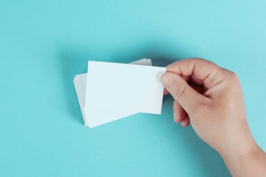 Holding a blank business card in the hand, copy space for text, marketing and advertising concept