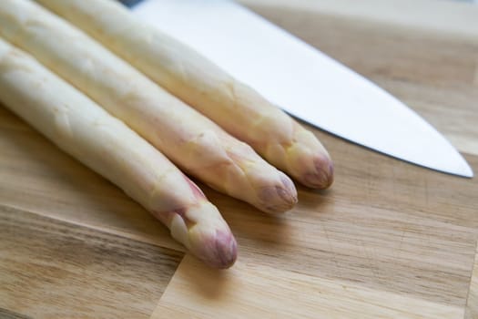 Fresh white asparagus directly from the field on a kitchen table