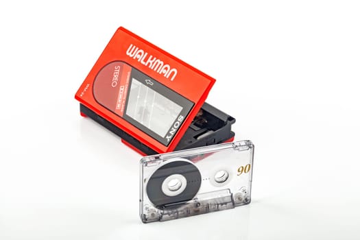 WETZLAR, GERMANY: 2022-04-16: Beautiful red vintage SONY WALKMAN WM-24 with audio tape over bright background.