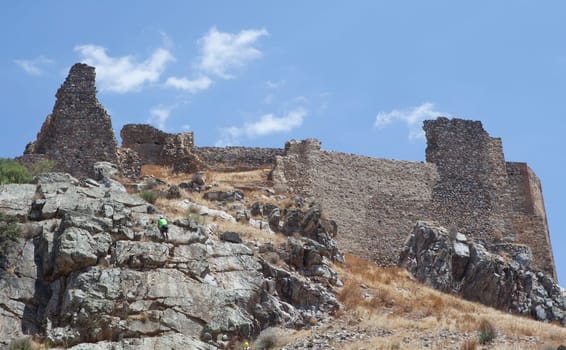 Rock climber ascending Magacela Castle hill. La Serena District, Extremadura, Spain
