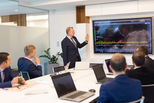 Business man making a presentation at office. Business executive delivering a presentation to his colleagues during meeting or in-house business training, explaining business plans to his employees.