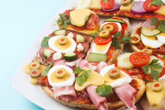 Brunch platter with decorated mini sandwiches, catering and food service industry.