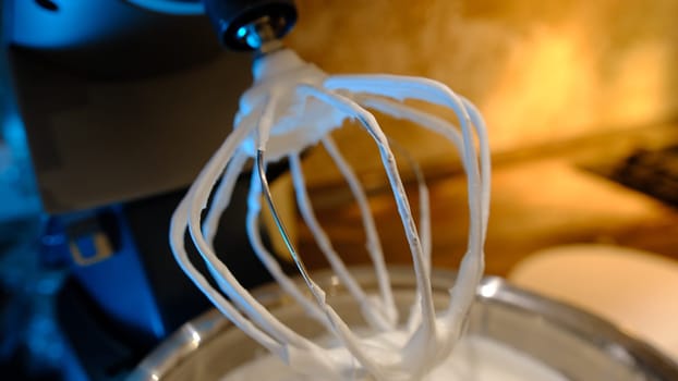 Beaten egg cream whites until frothy. Whipped egg whites for a meringue. Red stationary mixer, food processor take out beater.