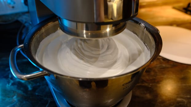 Beaten egg cream whites until frothy. Whipped egg whites for a meringue. Red stationary mixer, food processor take out beater.