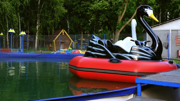view of inflatable boats in the form of birds swan, pelican on the water in the pool in the spring.