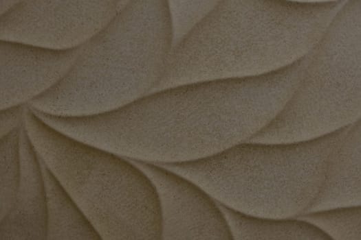 Beige ceramic tile with leaves pattern for wall and floor decoration. Concrete stone surface background. Texture for interior design project