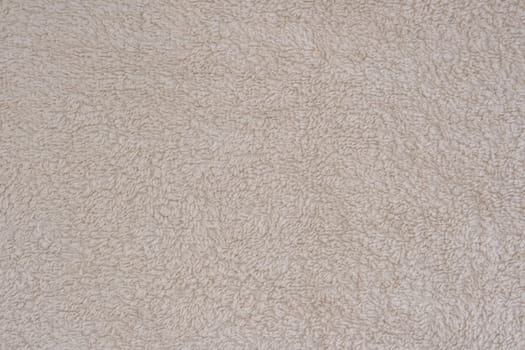 Fluffy gentle pastel biege fabric with waves and folds. Soft pastel textile texture