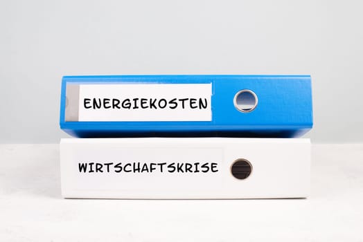 Energy prices and economic crisis are standing in german language on the folders, increasing prices , high living expenses, gas and electricity costs, inflation