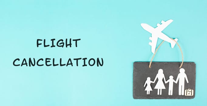The words flight cancellation are standing the paper, airplane cut out, staff shortage at the airport, vacation delayed for family
