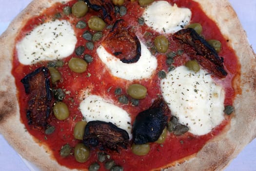 Pizza mit Büffelmozarella, Kapern, Oliven und getrockneten Tomaten