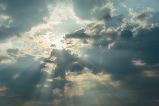 Glare of the sun and rays with clouds, sky background