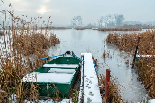 A boat at the pier on a frozen lake, Stankow, Lubelskie, Poland