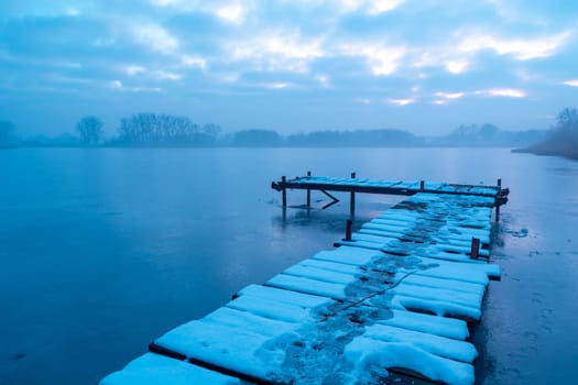 A pier on a frozen and misty lake, Stankow, Poland