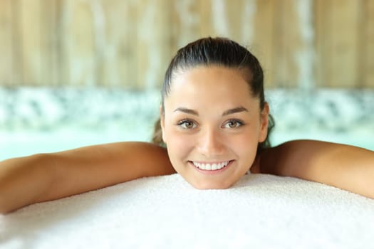 Front view portrait of a beautiful woman looking at you in spa pool